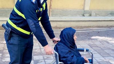 بكرسى متحرك .. نقيب يساعد مُسنة أثناء العملية الانتخابية بقنا