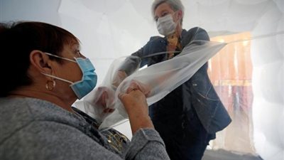 خوفاً من كورونا ومن الموت المفاجئ.. اختراع أبواب بلاستيك للسلام والأحضان بين المسنين وأهاليهم