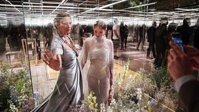 عارضة أزياء وابنتها تشاركان في عرض أزياء في باريس.. العارضات بعيدات عن الجمهور  داخل أقفاص زجاجية