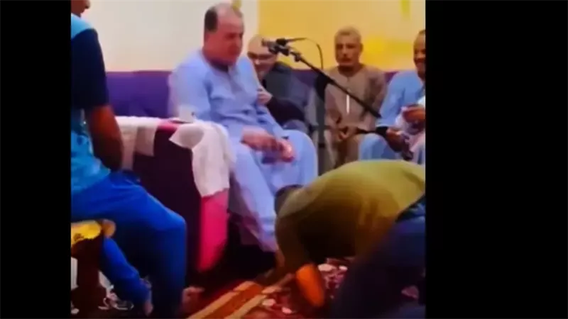 شاب يقبل قدم الشيخ