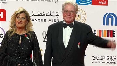 بعلم فلسطين.. حسين فهمي وزوجته أول الحضور في افتتاح مهرجان القاهرة السينمائي