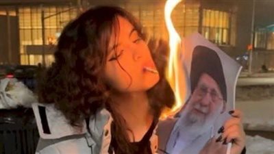 صورة صادمة تشعل الجدل.. فتيات إيران يحتججن بحرق صورة خامنئي وإشعال السجائر